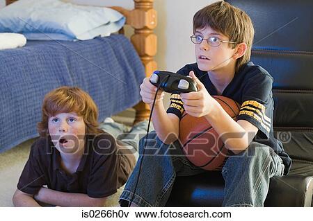 Two boys playing a computer game View Large Photo Image Stock Photo - Two boys playing a computer game. Fotosearch