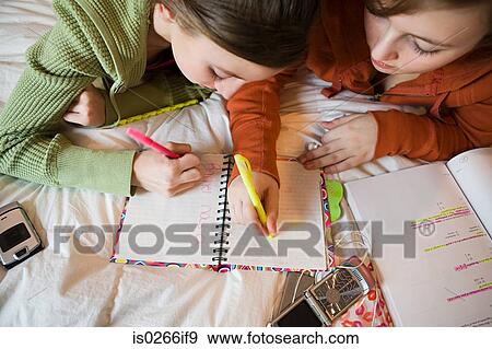 Stock Photo - Two teenage girls writing in a book. Fotosearch