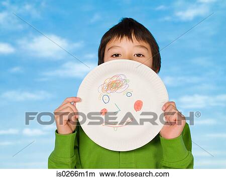 A boy holding a paper plate with a drawing on it View Large Photo Image Picture - A boy holding a paper plate with a drawing on it. Fotosearch