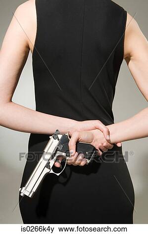 A woman concealing a gun View Large Photo Image Stock Photo - A woman concealing a gun. Fotosearch