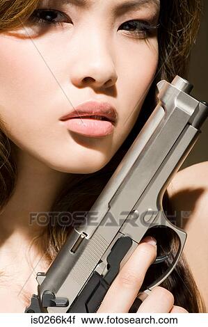 A woman holding a gun View Large Photo Image Stock Image - A woman holding a gun. Fotosearch