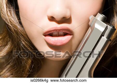 Stock Image - A woman holding a gun. Fotosearch