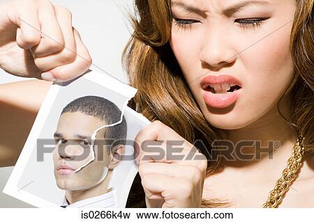 A young woman ripping a photograph of a man View Large Photo Image Stock Photo - A young woman ripping a photograph of a man. Fotosearch
