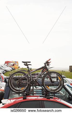Stock Image - Bicycles on car in car park. Fotosearch