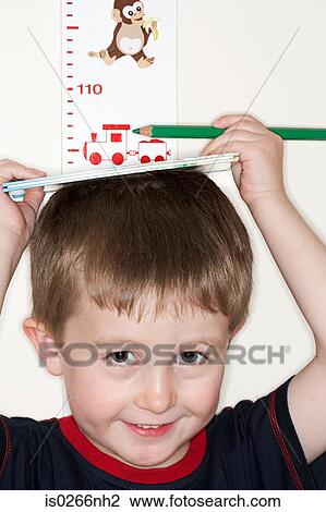 Boy measuring his height View Large Photo Image Stock Image - Boy measuring his height. Fotosearch