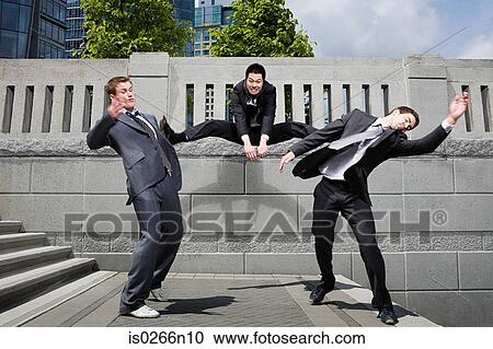 Stock Image - Businessman kicking rivals. Fotosearch