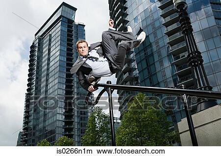 Businessman swinging on railing View Large Photo Image Picture - Businessman swinging on railing. Fotosearch