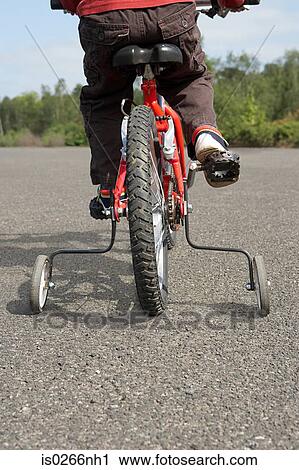 Child on a bicycle with stabilisers View Large Photo Image Stock Image - Child on a bicycle with stabilisers. Fotosearch