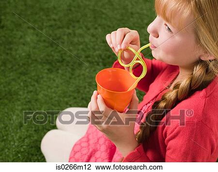 Girl drinking through a straw View Large Photo Image Stock Image - Girl drinking through a straw. Fotosearch