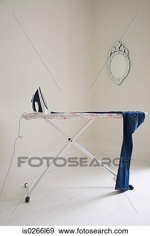 Iron on ironing board View Large Photo Image Stock Photo - Iron on ironing board. Fotosearch