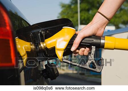 Stock Photograph - Person using petrol pump. Fotosearch