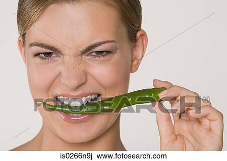 Woman biting chilli pepper View Large Photo Image Stock Image - Woman biting chilli pepper. Fotosearch