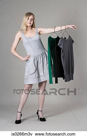 Stock Photo - Woman hanging clothes on her arm. Fotosearch