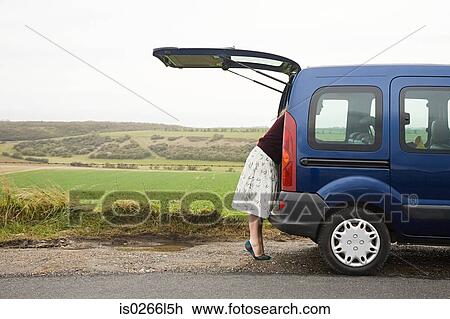 Woman looking in car boot View Large Photo Image Stock Image - Woman looking in car boot. Fotosearch