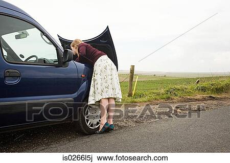 Woman looking under car bonnet View Large Photo Image Stock Image - Woman looking under car bonnet. Fotosearch