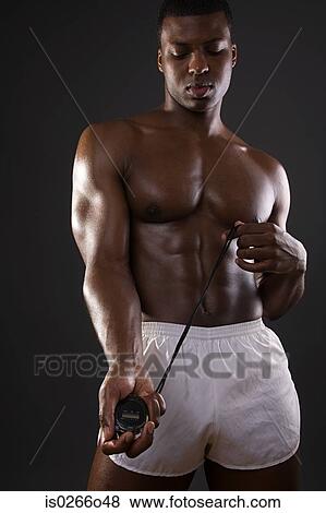 Stock Photo - Young man holding a stopwatch. Fotosearch