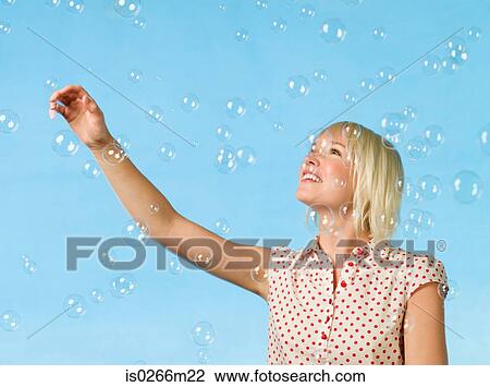 Young woman catching bubbles View Large Photo Image Stock Image - Young woman catching bubbles. Fotosearch
