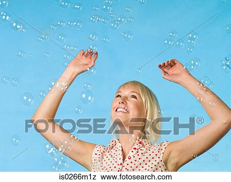 Young woman catching bubbles View Large Photo Image Stock Photo - Young woman catching bubbles. Fotosearch