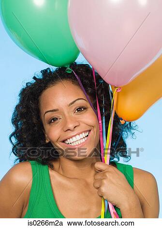 Young woman holding balloons View Large Photo Image Stock Image - Young woman holding balloons. Fotosearch