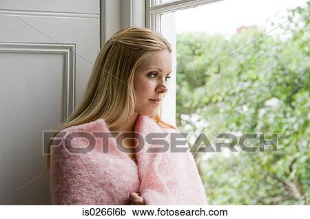 Young woman looking through window View Large Photo Image Stock Image - Young woman looking through window. Fotosearch