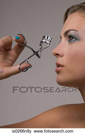 Young woman with eyelash curlers View Large Photo Image Stock Photo - Young woman with eyelash curlers. Fotosearch