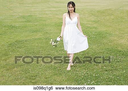 Bride walking on grass View Large Photo Image Stock Photograph - Bride walking on grass. Fotosearch