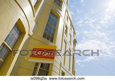 Stock Image - Building and for sale sign. Fotosearch