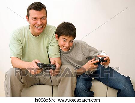 Stock Image - Father and son playing video game. Fotosearch