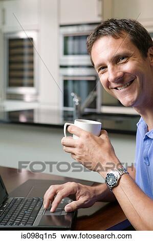 Man with laptop and coffee cup View Large Photo Image Stock Photography - Man with laptop and coffee cup. Fotosearch
