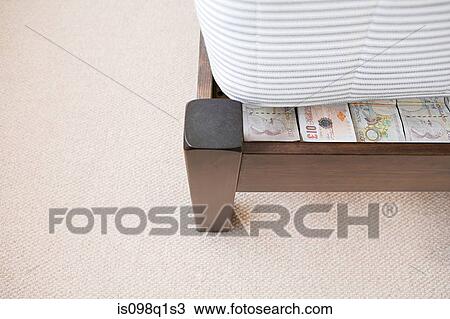 Stock Image - Money hidden under a mattress. Fotosearch