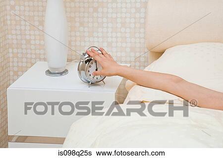 Reaching for alarm clock View Large Photo Image Stock Photograph - Reaching for alarm clock. Fotosearch