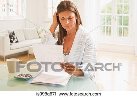 Stock Image - Woman looking at letter. Fotosearch