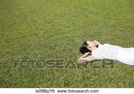 Woman lying on grass View Large Photo Image Stock Photography - Woman lying on grass. Fotosearch