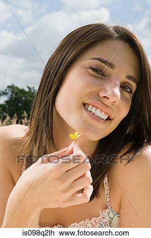 Stock Image - Woman with a buttercup. Fotosearch