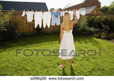Woman with baby clothes on clothes line View Large Photo Image Stock Image - Woman with baby clothes on clothes line. Fotosearch