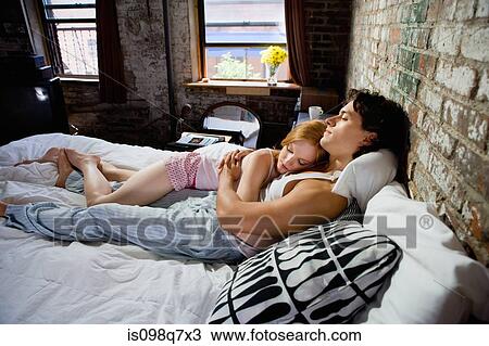 Stock Image - Couple hugging on bed. Fotosearch