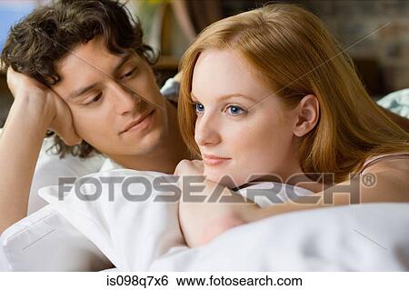 Stock Photograph - Couple relaxing in bed. Fotosearch
