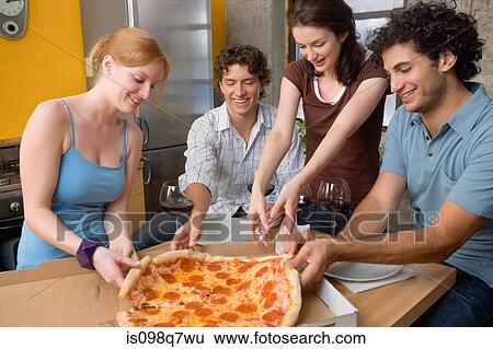 Friends sharing a pizza View Large Photo Image Stock Photograph - Friends sharing a pizza. Fotosearch