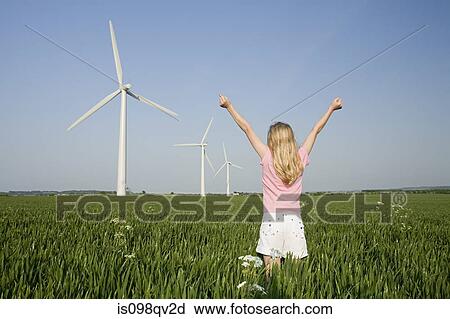 Girl in a field by wind farm View Large Photo Image Stock Image - Girl in a field by wind farm. Fotosearch