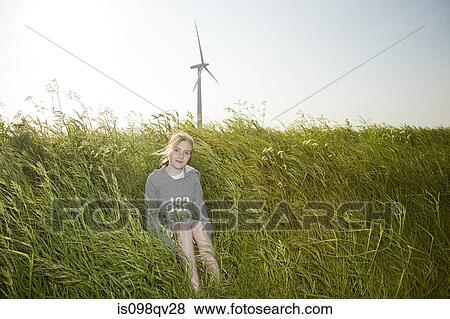 Girl in a field by wind farm View Large Photo Image Stock Photo - Girl in a field by wind farm. Fotosearch