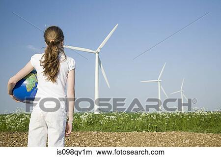 Girl with globe by wind turbines View Large Photo Image Picture - Girl with globe by wind turbines. Fotosearch