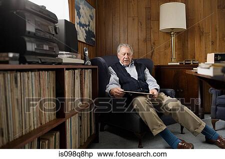 Senior man looking at a vinyl record View Large Photo Image Stock Photography - Senior man looking at a vinyl record. Fotosearch