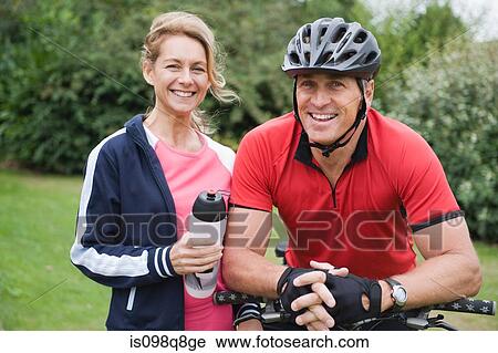 Smiling couple with cycling gear View Large Photo Image Stock Image - Smiling couple with cycling gear. Fotosearch
