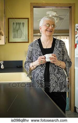 Stock Photo - Smiling senior woman holding a cup. Fotosearch