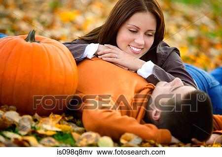Young couple lying on the leaves View Large Photo Image Stock Photo - Young couple lying on the leaves. Fotosearch