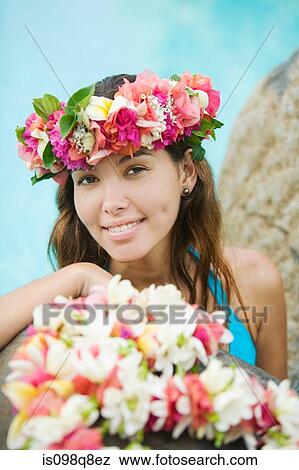 Stock Photo - Young woman with flowers in hair in moorea. Fotosearch
