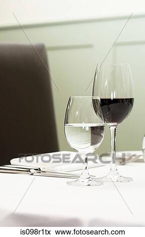 A glass of water and red wine on a table View Large Photo Image Stock Photo - A glass of water and red wine on a table. Fotosearch