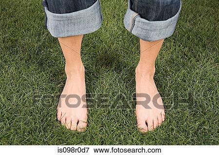 Stock Photo - A woman standing on grass. Fotosearch