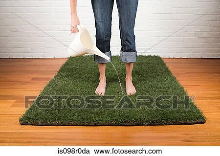 A woman watering grass View Large Photo Image Stock Image - A woman watering grass. Fotosearch