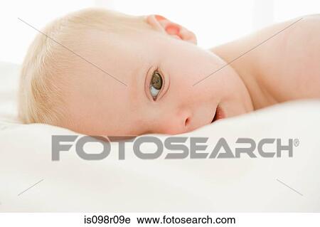 Baby boy lying on a bed View Large Photo Image Stock Image - Baby boy lying on a bed. Fotosearch